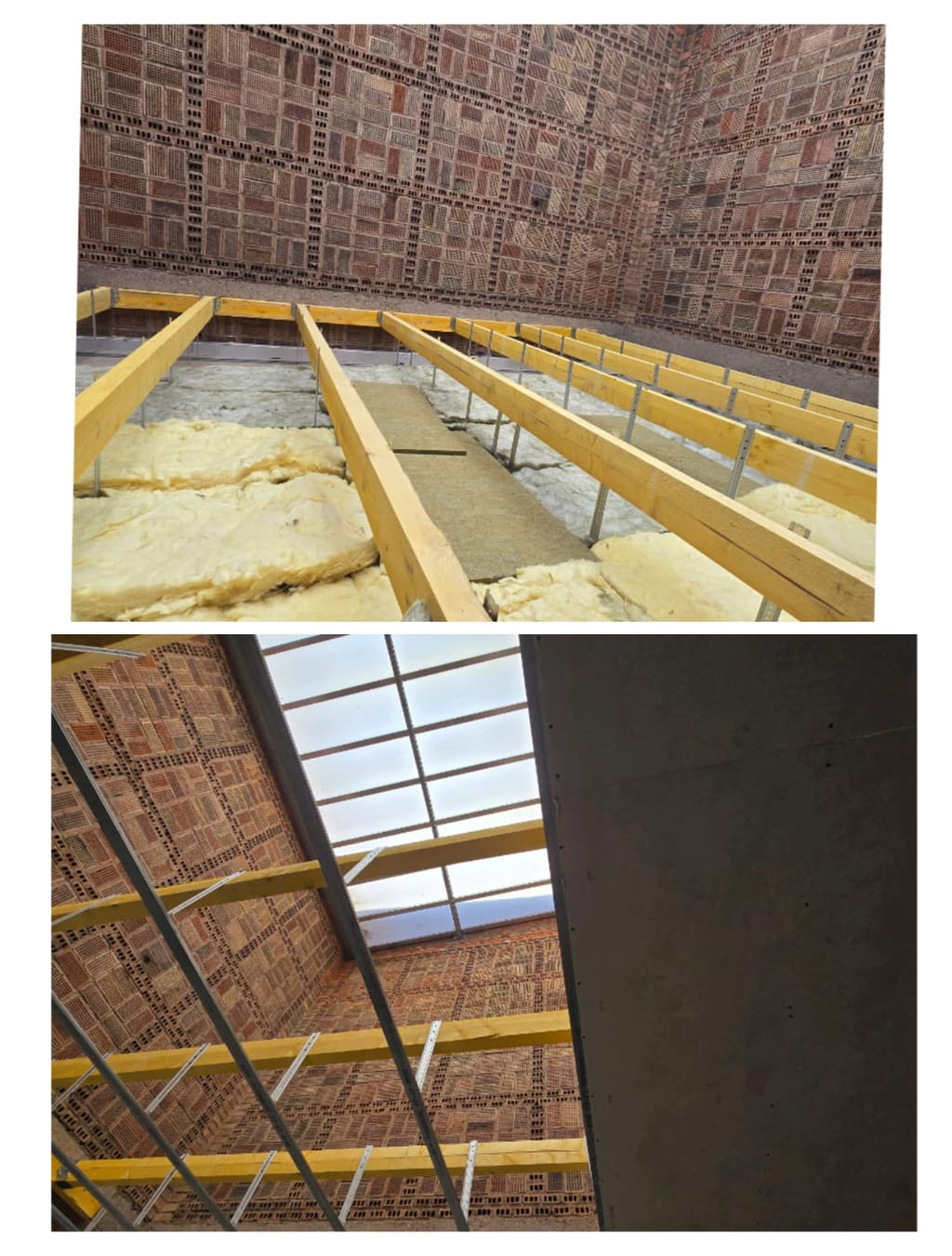 Ossature d'un faux plafond avant habillage : rails métalliques posés entre les solives et panneaux isolants glissés entre les fermes de la charpente, sous une toiture en brique et une verrière.